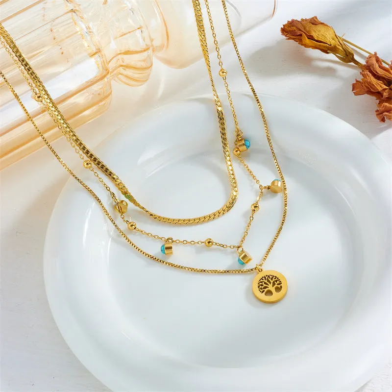 Gold-plated multi-layer stainless steel necklace with geometric tree pendant on woman