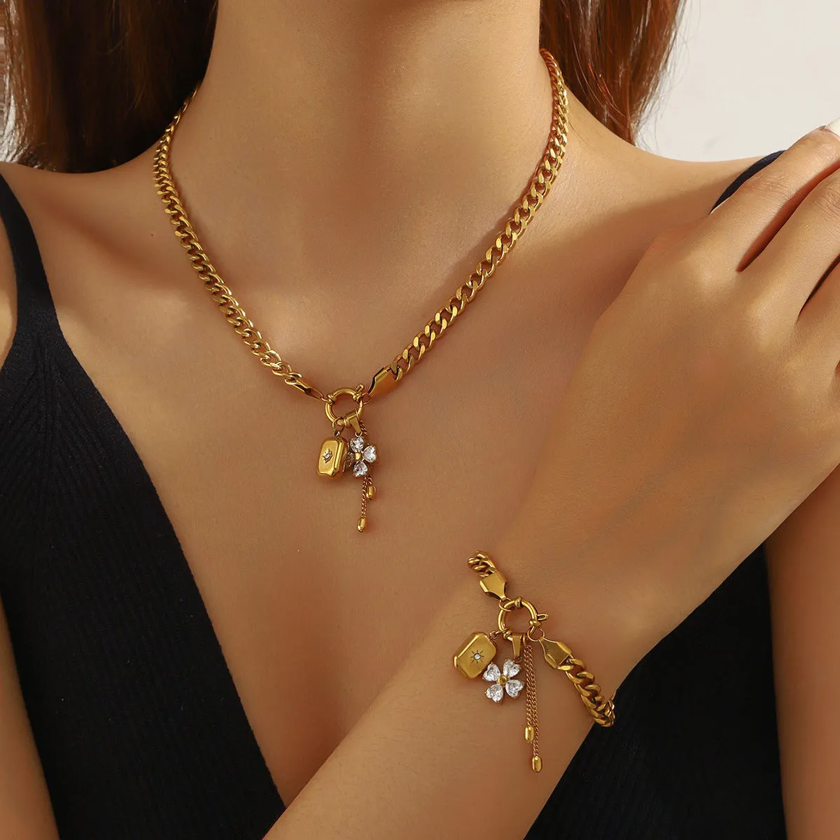 Tassel stainless steel bracelet and necklace set for women with flower and butterfly motifs on a white background