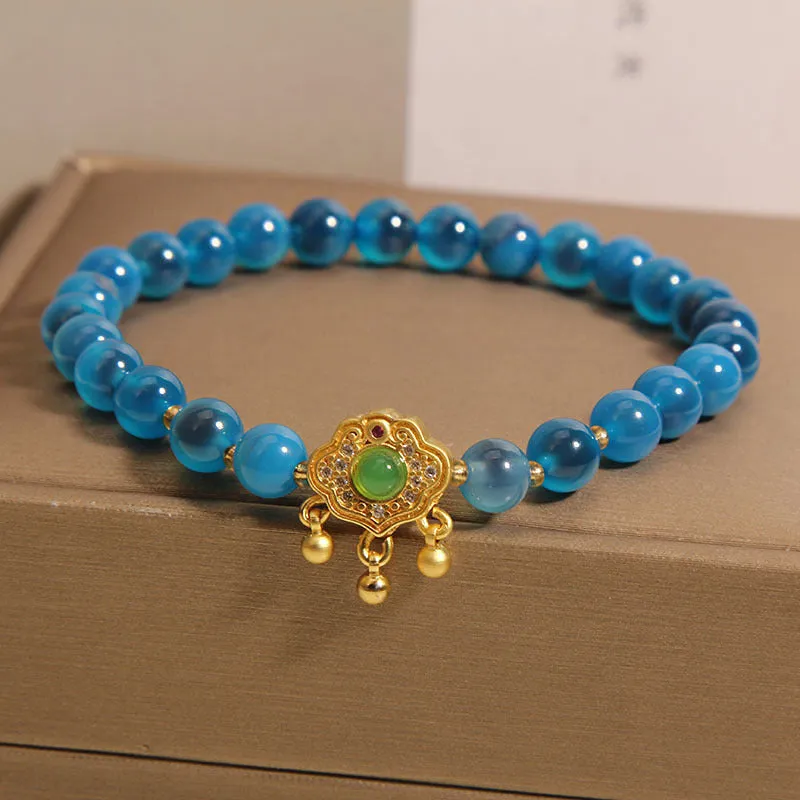Blue sugar heart agate safety lock pendant on a women's crystal bracelet with rhinestone details.