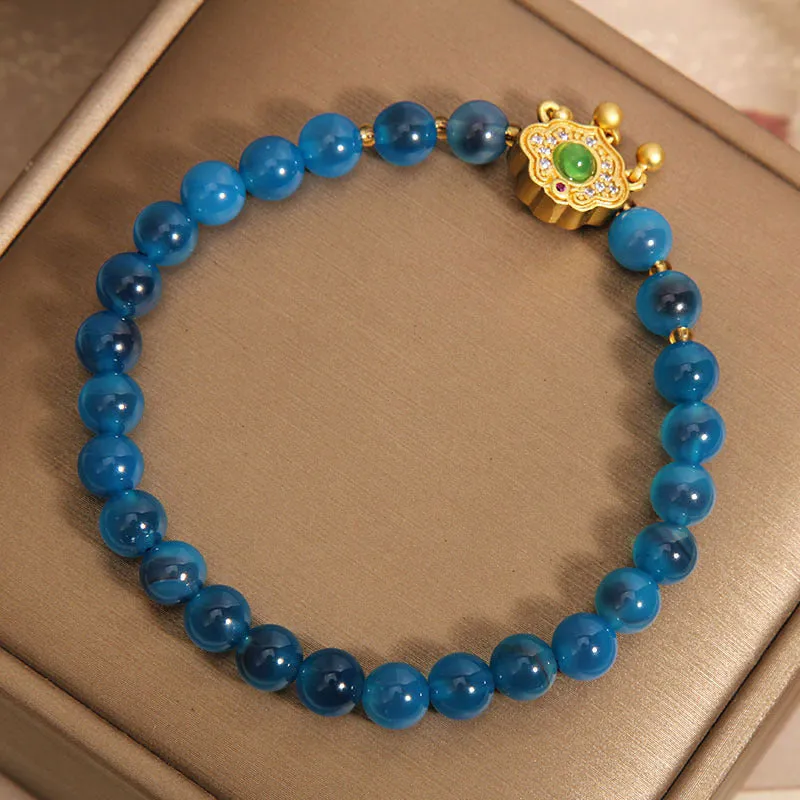 Blue sugar heart agate safety lock pendant on a women's crystal bracelet with rhinestone details.