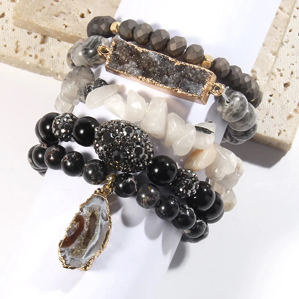 Set of five handmade stretch bracelets with glass, crystal, and hematite beads in irregular shapes on a neutral background