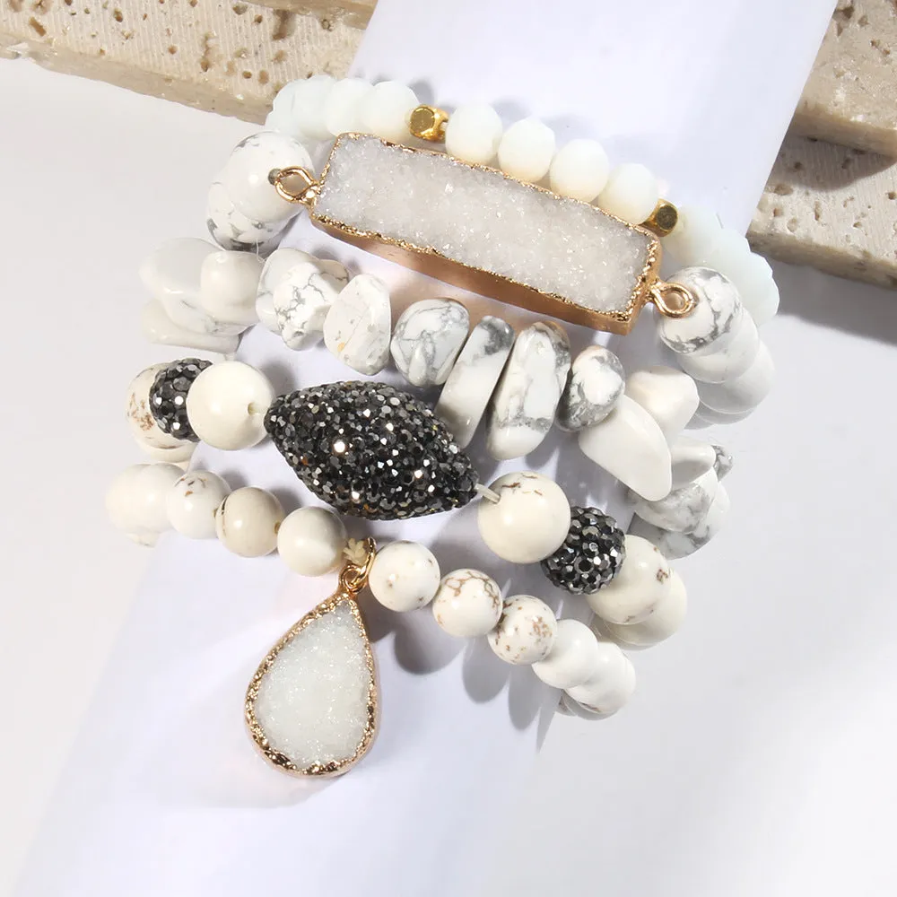 Set of five handmade stretch bracelets with glass, crystal, and hematite beads in irregular shapes on a neutral background
