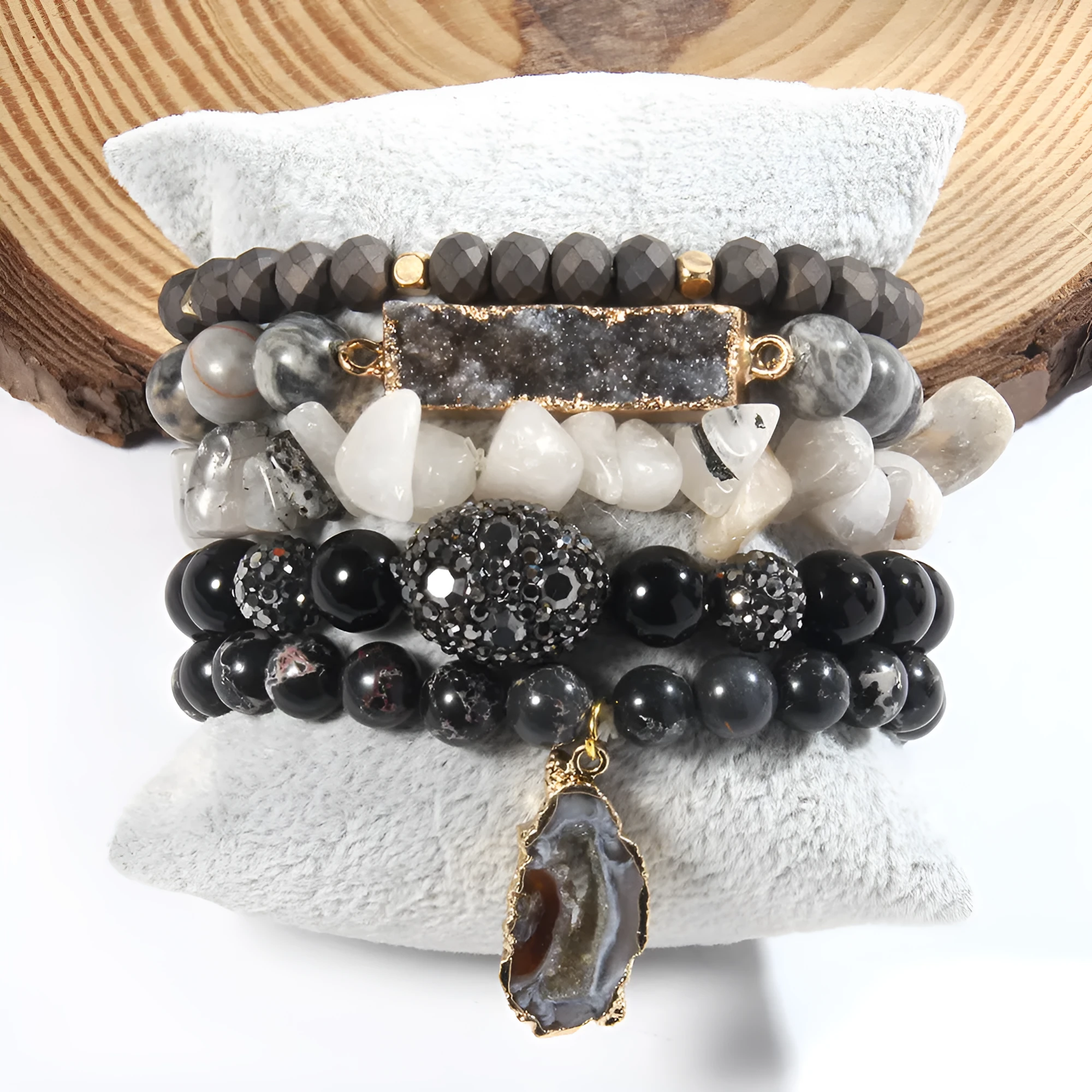 Set of five handmade stretch bracelets with glass, crystal, and hematite beads in irregular shapes on a neutral background