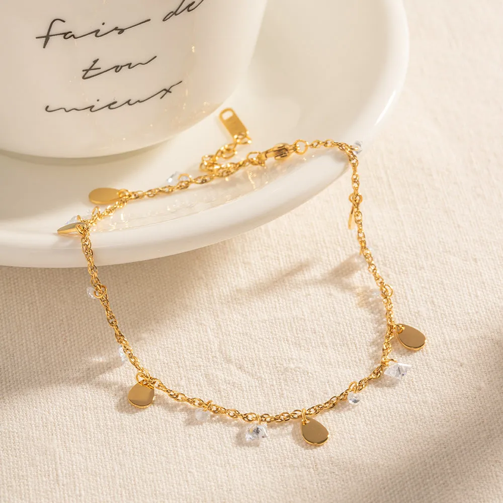 Stainless steel women's anklet with a geometric water drop tassel charm on an ankle.