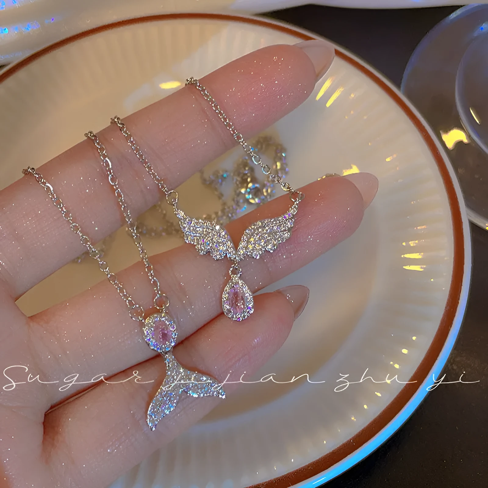 Women's sterling silver necklace showing Angel Wings and Fishtail pendant options on an adjustable O-ring chain.