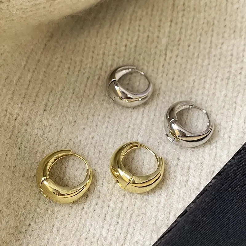Pair of simple retro geometric alloy earrings in gold electroplated finish on a light background