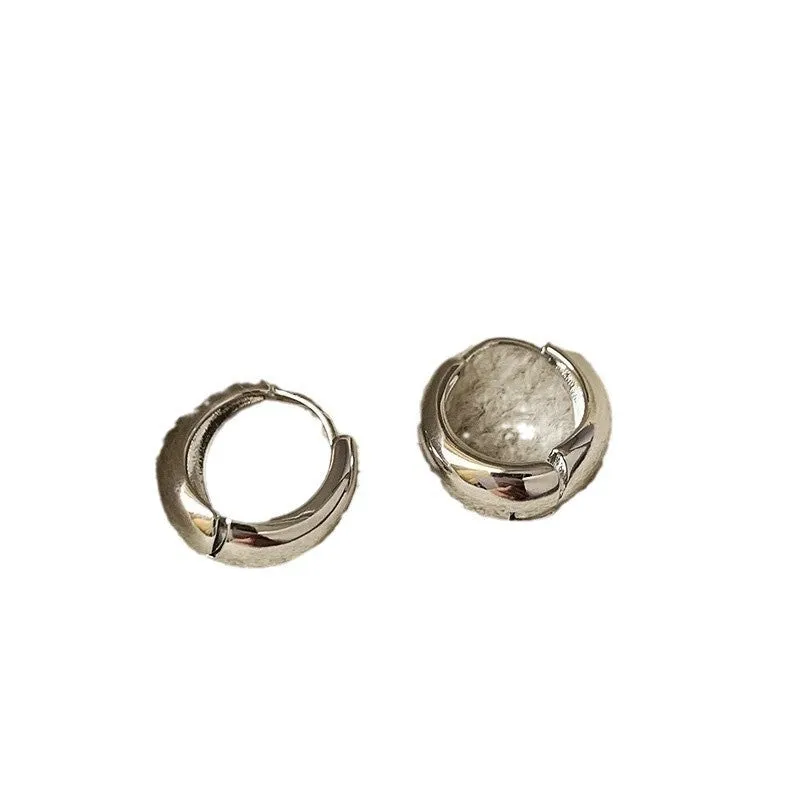 Pair of simple retro geometric alloy earrings in gold electroplated finish on a light background