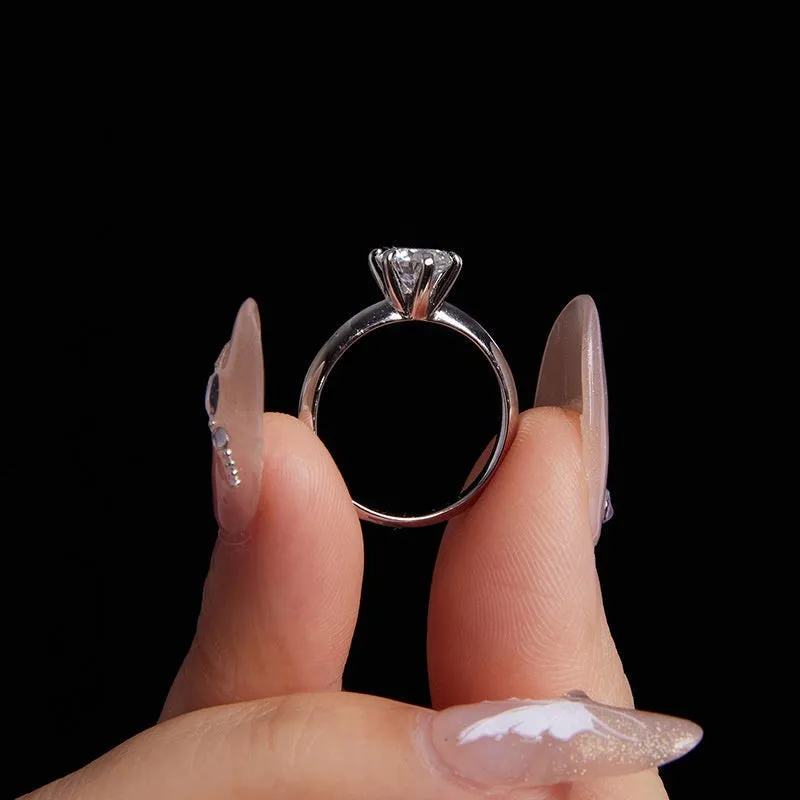 Simple classic 6 claw 1 karat moissanite ring in silver on white background, US size 7