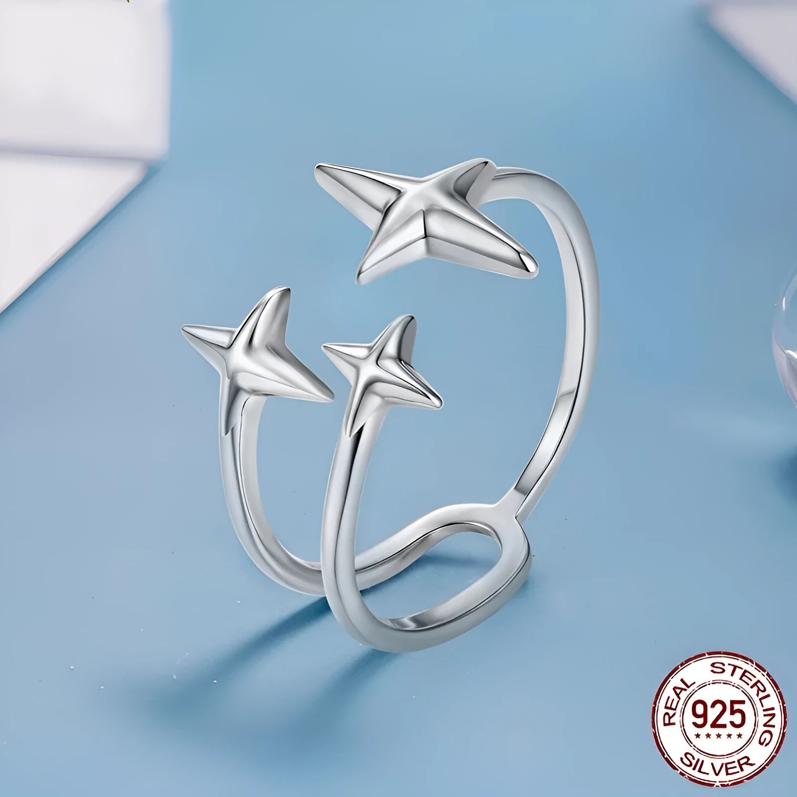 S925 sterling silver shining star open ring with polished finish and adjustable opening on a plain background