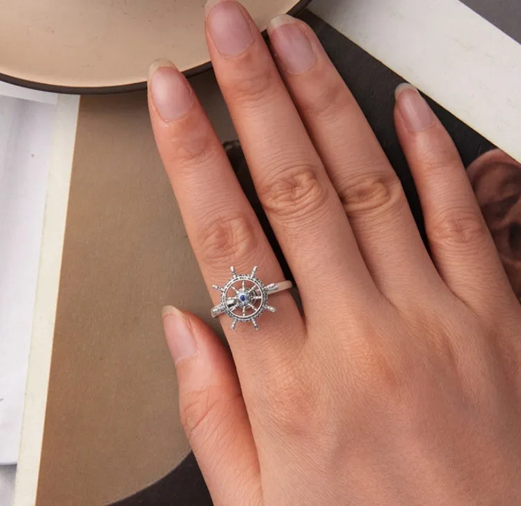 Retro women's silver ring with rotatable rudder design and inlaid zircon stone on open mouth band.