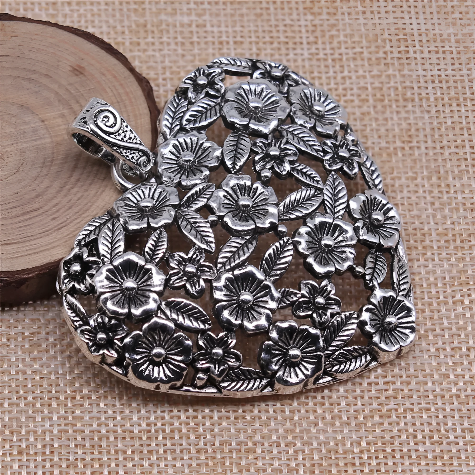 Ancient silver hollow flower love pendant measuring 67mm by 58mm with electroplated finish
