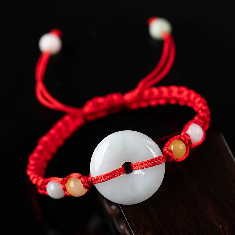 Round emerald green Burma jade pendant on an adjustable red rope bracelet strap.