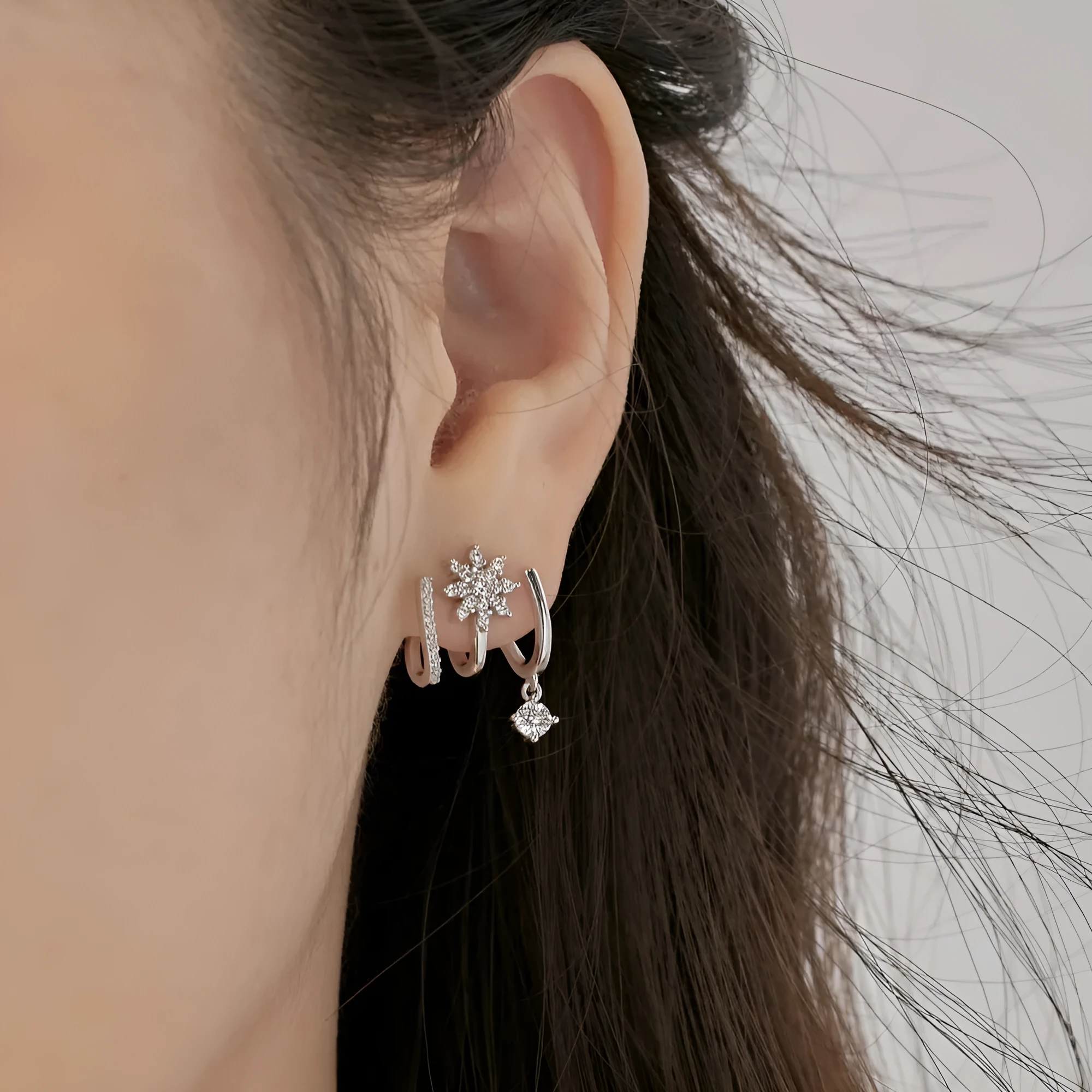 S925 sterling silver snowflake stud earrings in platinum finish with electroplated surface on white background
