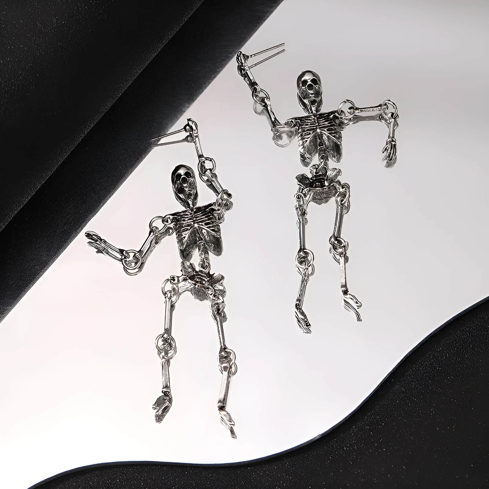Exaggerated skull frame earrings in antique silver, zinc alloy electroplated finish, unisex design with hook fastening on white background
