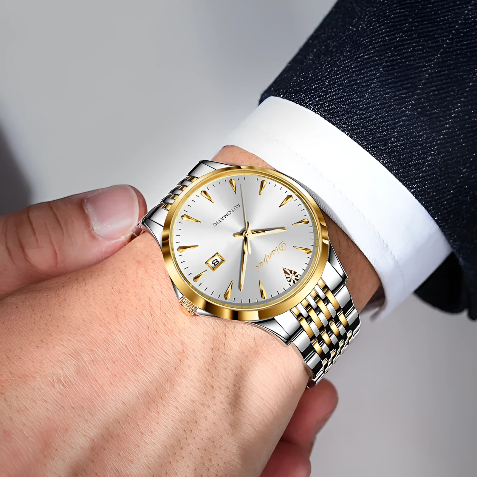 Men's stainless steel automatic mechanical watch with simple white dial on wrist.
