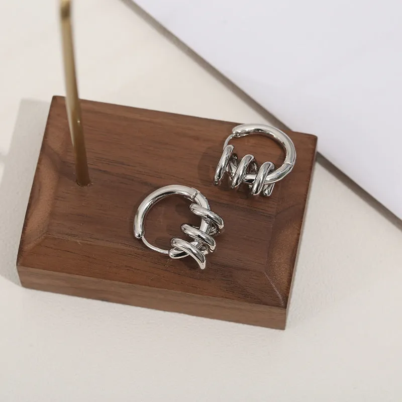 Spiral wound ear clip frosty style geometric earrings in gold colour on white background