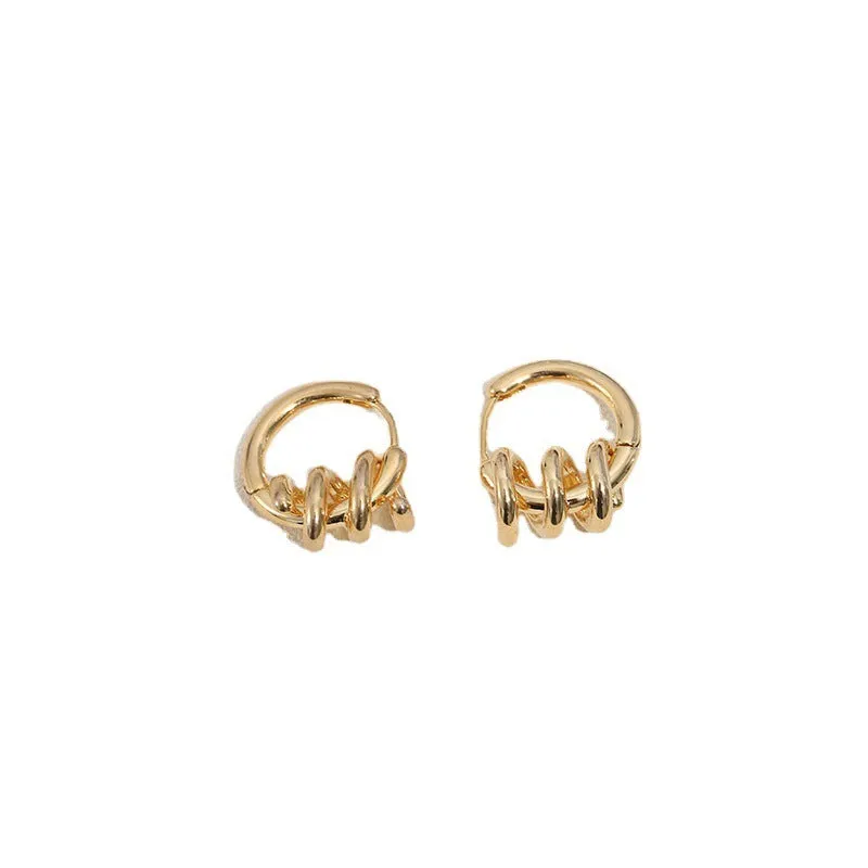Spiral wound ear clip frosty style geometric earrings in gold colour on white background