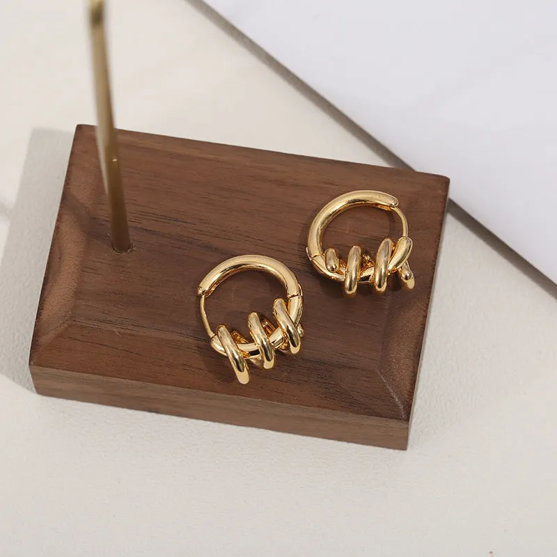 Spiral wound ear clip frosty style geometric earrings in gold colour on white background