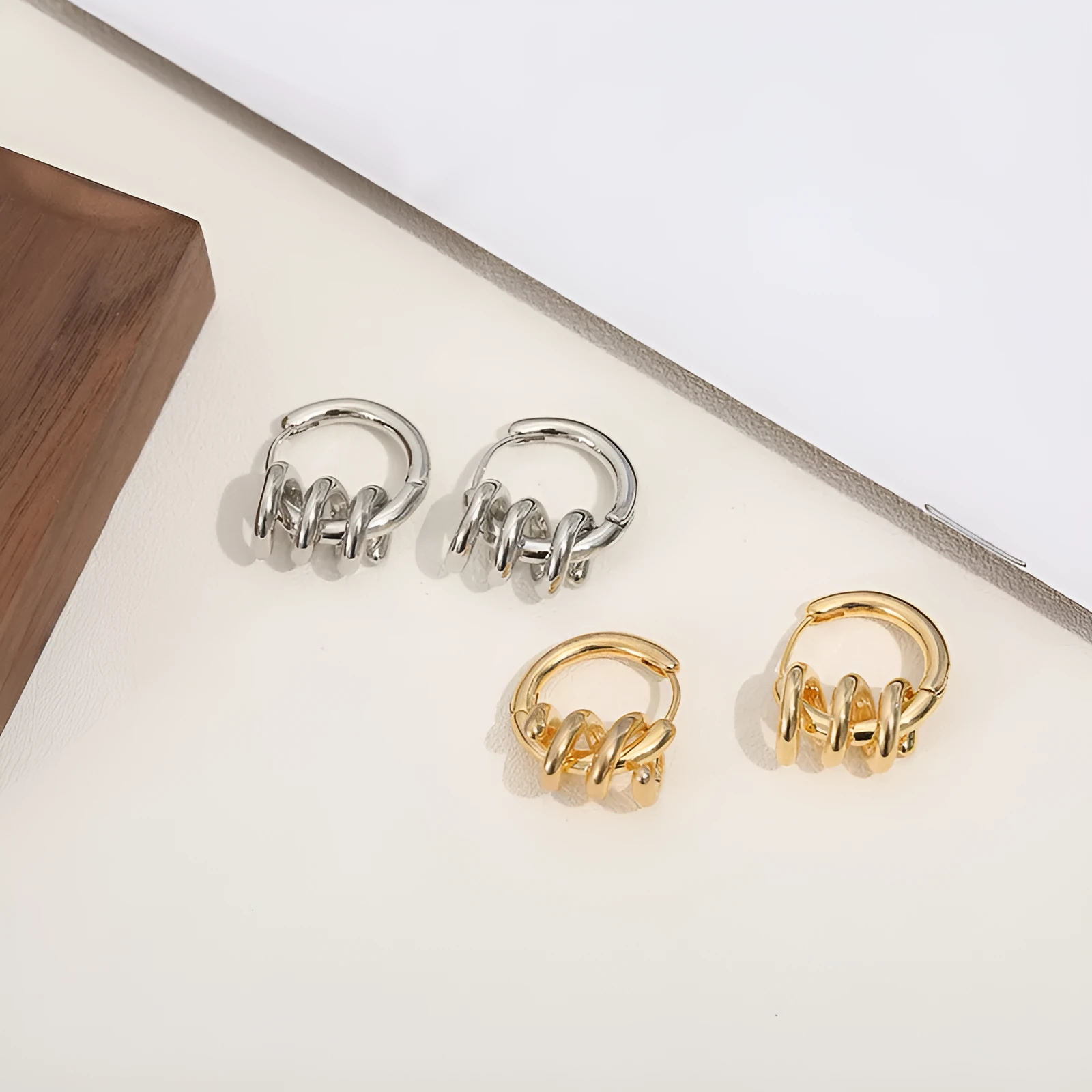 Spiral wound ear clip frosty style geometric earrings in gold colour on white background