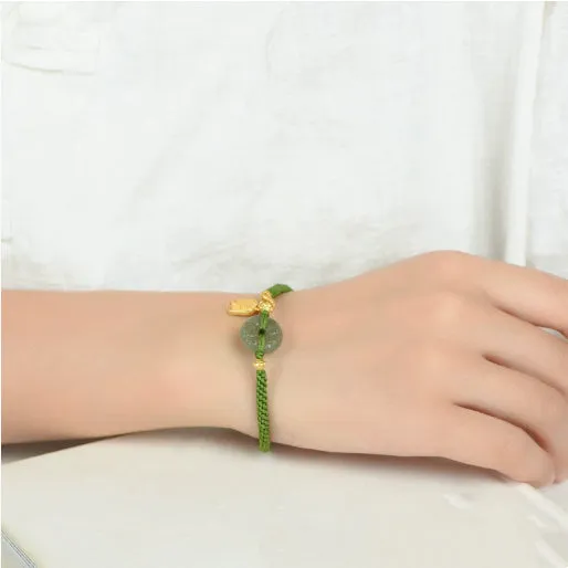 Close-up of a women's hand-woven green rope bracelet with a Hetian jade peace buckle charm.