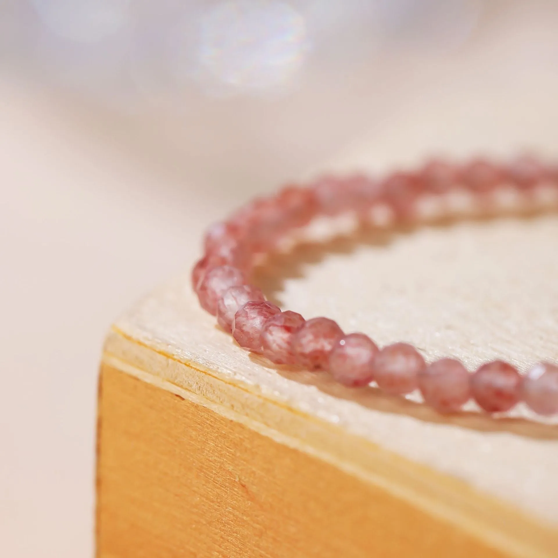 Natural strawberry quartz bracelet with 3mm polished diamond-cut beads on an adjustable cord