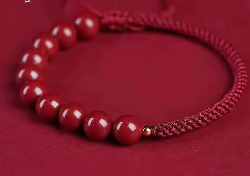 Braided rope bracelet with cinnabar beads in 8mm diameter and wine red colour