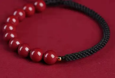 Braided rope bracelet with cinnabar beads in 8mm diameter and wine red colour