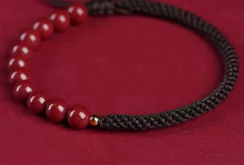 Braided rope bracelet with cinnabar beads in 8mm diameter and wine red colour