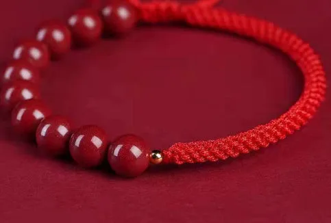 Braided rope bracelet with cinnabar beads in 8mm diameter and wine red colour