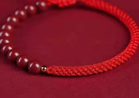 Braided rope bracelet with cinnabar beads in 8mm diameter and wine red colour