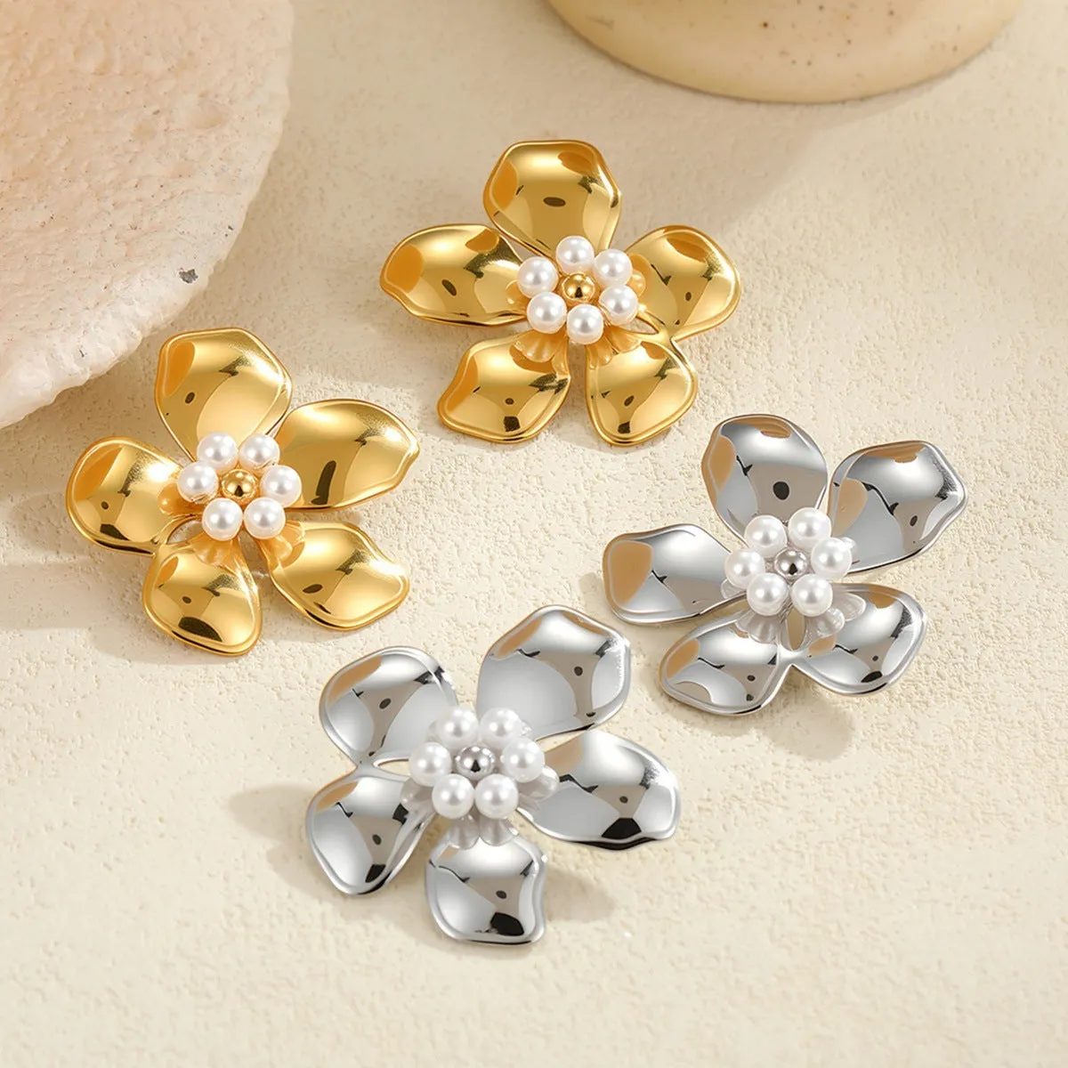 Flower stringed pearls stud earrings in gold and steel colour on white background