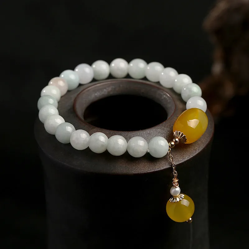 Women's ethnic style geometric bracelet with hanging agate tassel and 14K gilded details.