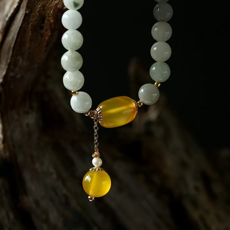 Women's ethnic style geometric bracelet with hanging agate tassel and 14K gilded details.
