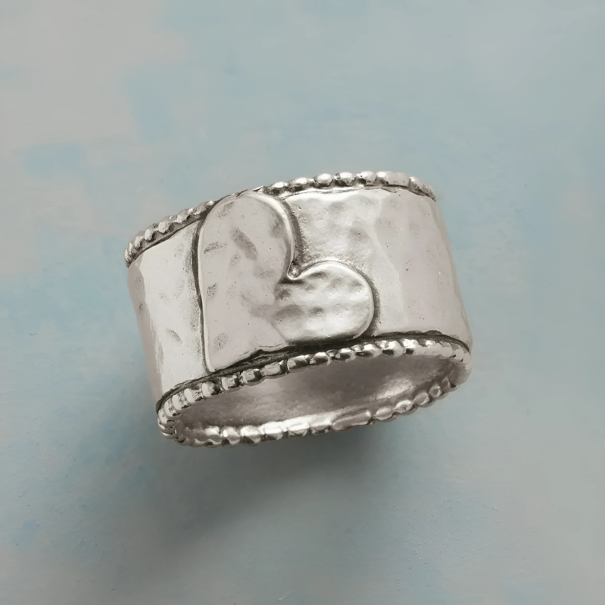 Antique silver heart-shaped hammered ring on finger, zinc alloy, sizes No 7 to 11