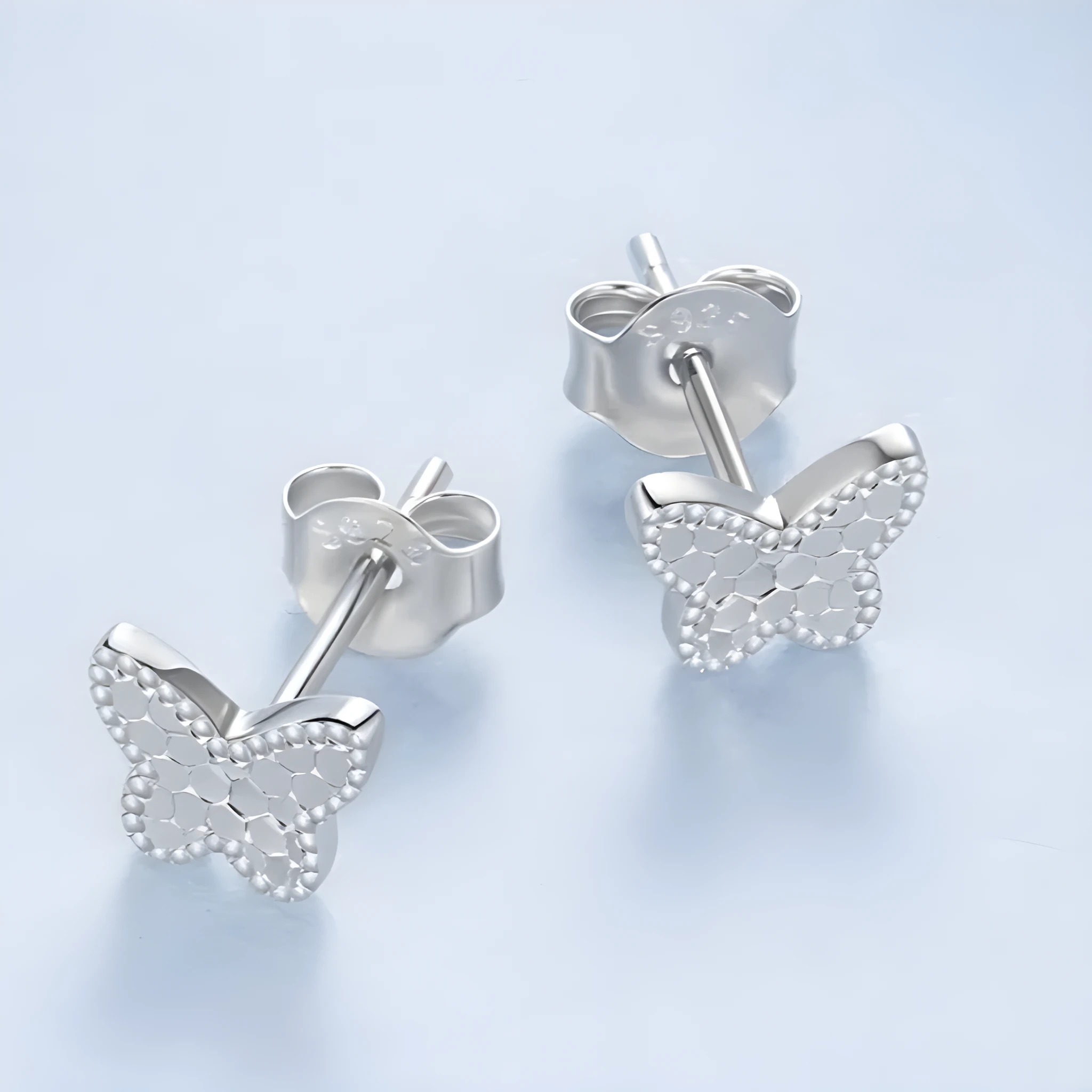 Pair of original S925 sterling silver butterfly stud earrings with shiny electroplated finish on white background