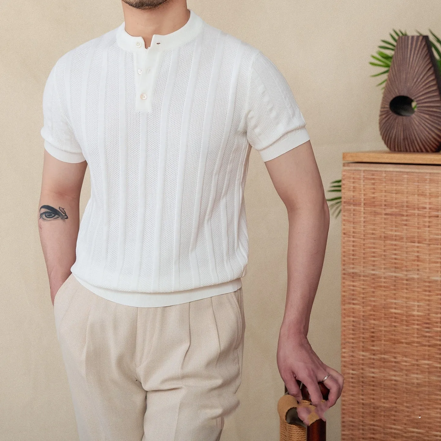 Men's creamy-white Henry collar cotton T-shirt with sunken stripe design on thin fabric.