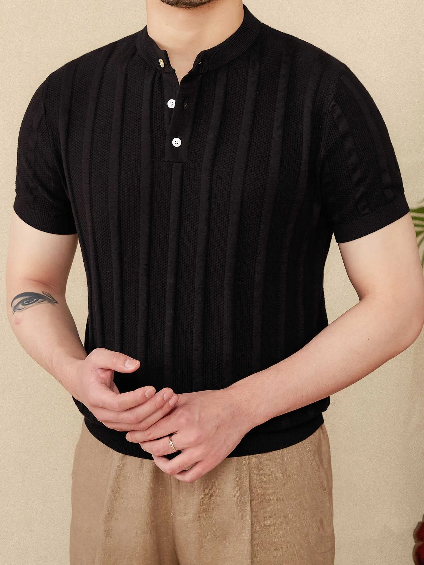 Men's creamy-white Henry collar cotton T-shirt with sunken stripe design on thin fabric.