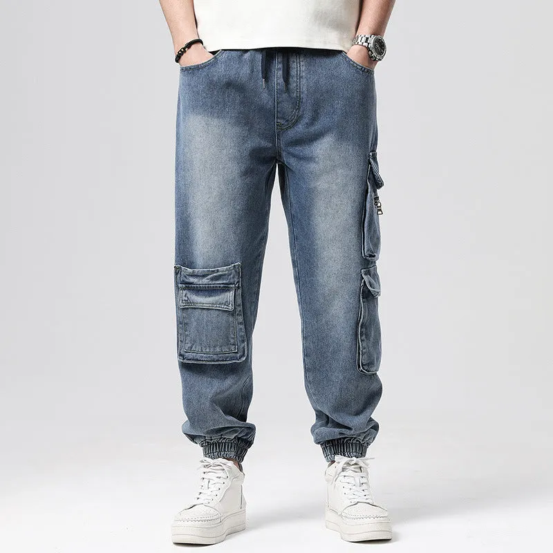 Man wearing loose-fit blue denim hip hop trousers with multiple pockets and a straight leg.