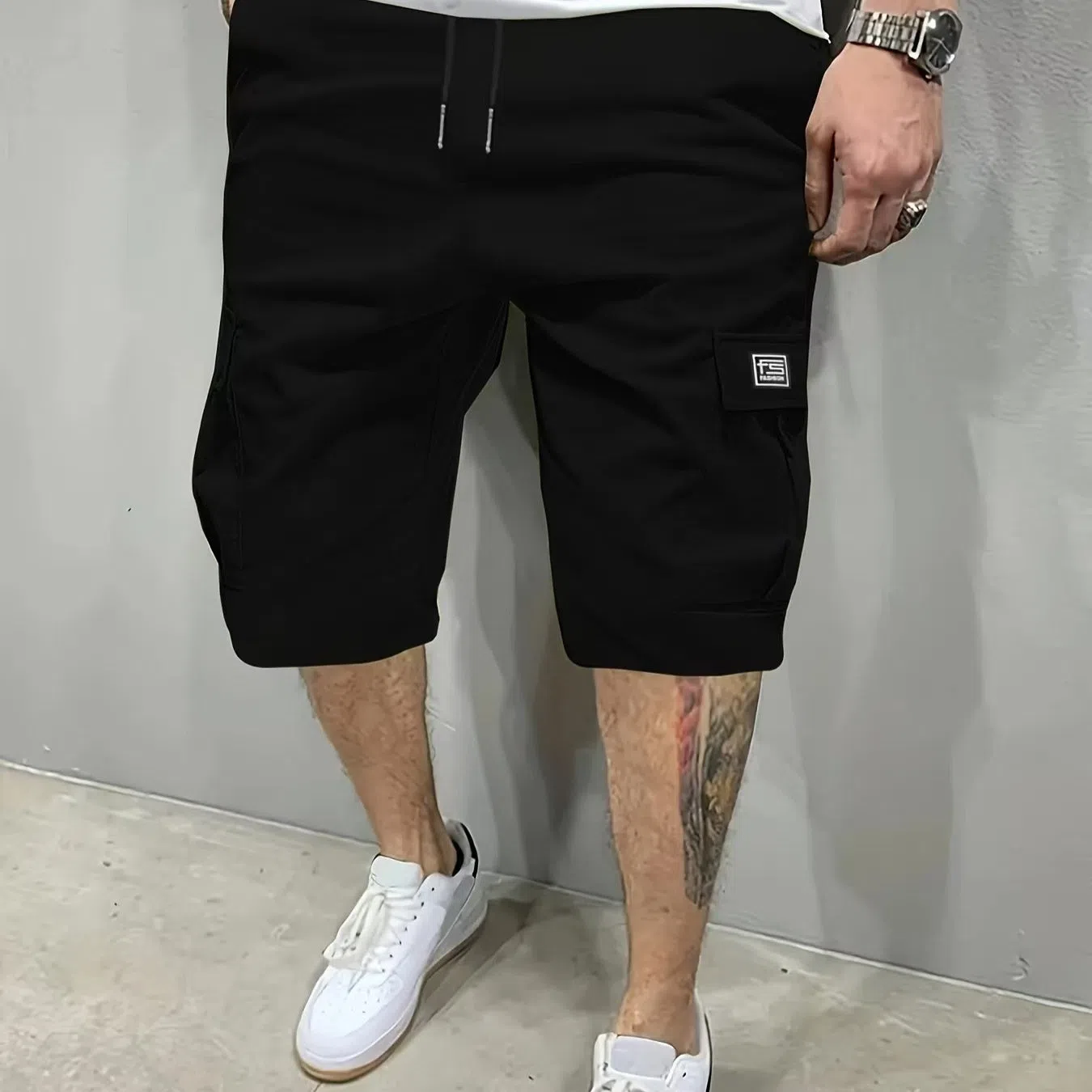 Men's polyester straight-leg shorts in black showing side pocket and waistband detail