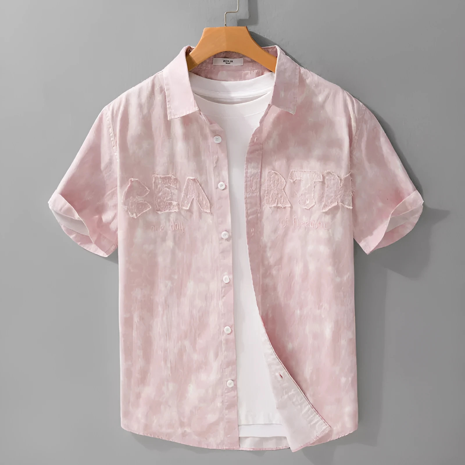 Men's grey white loose fit short sleeve cotton cardigan with a hanging dyed print, shown on a hanger.