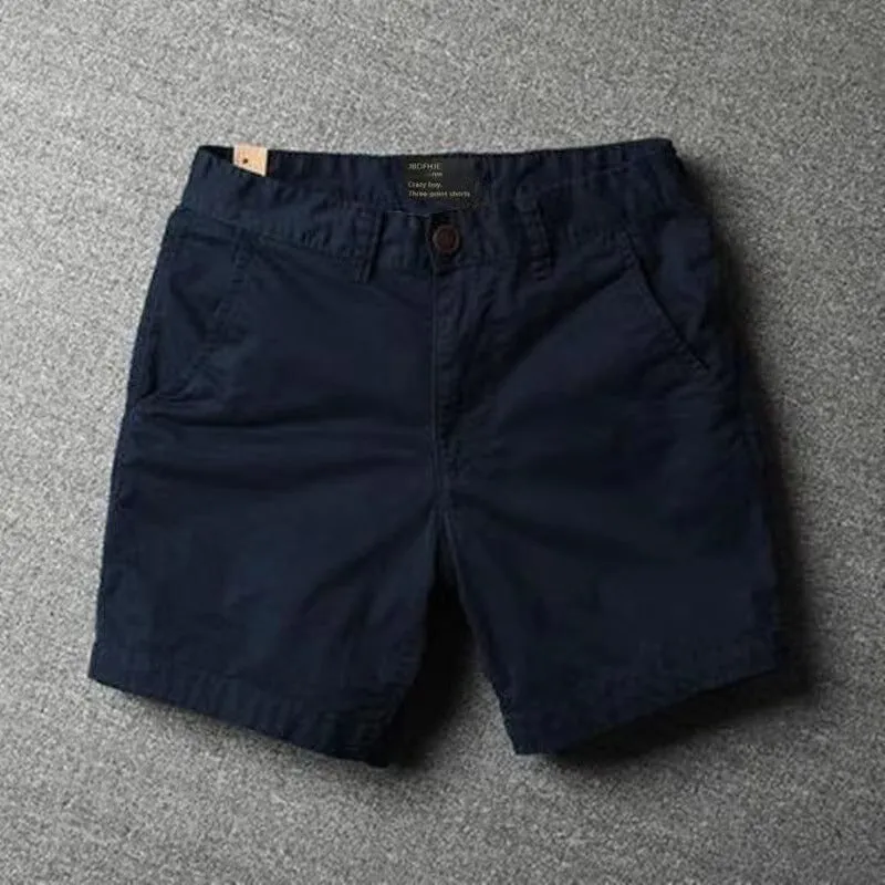 Men's loose straight-leg cotton shorts in solid colours on a hanger