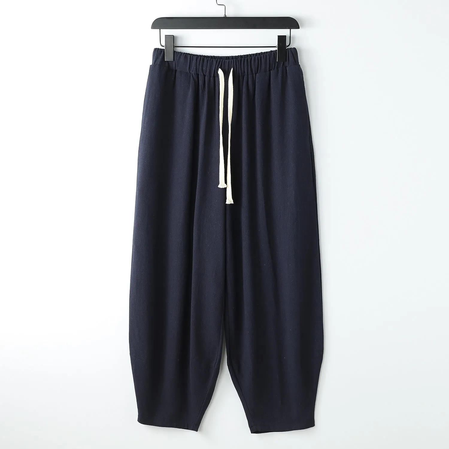 Linen harem pants for men with loose tapered fit and ankle-tied cuffs, shown in grey.