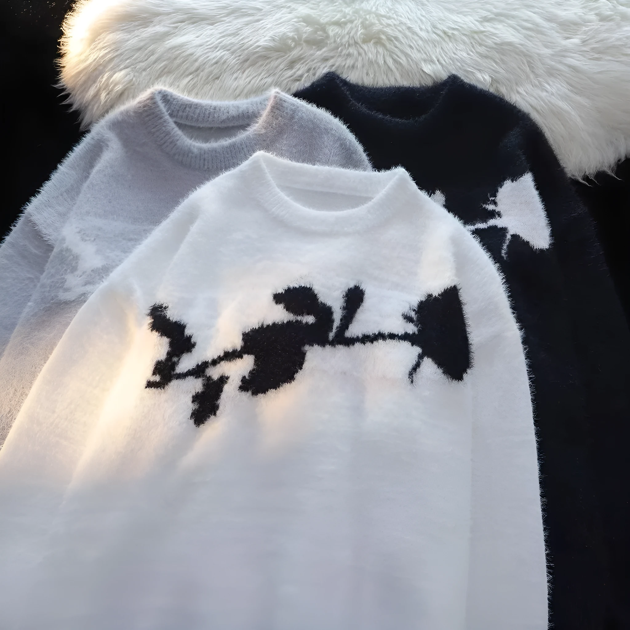 Man wearing a dark grey pullover sweater with a large rose-coloured flocking horse print on the chest.