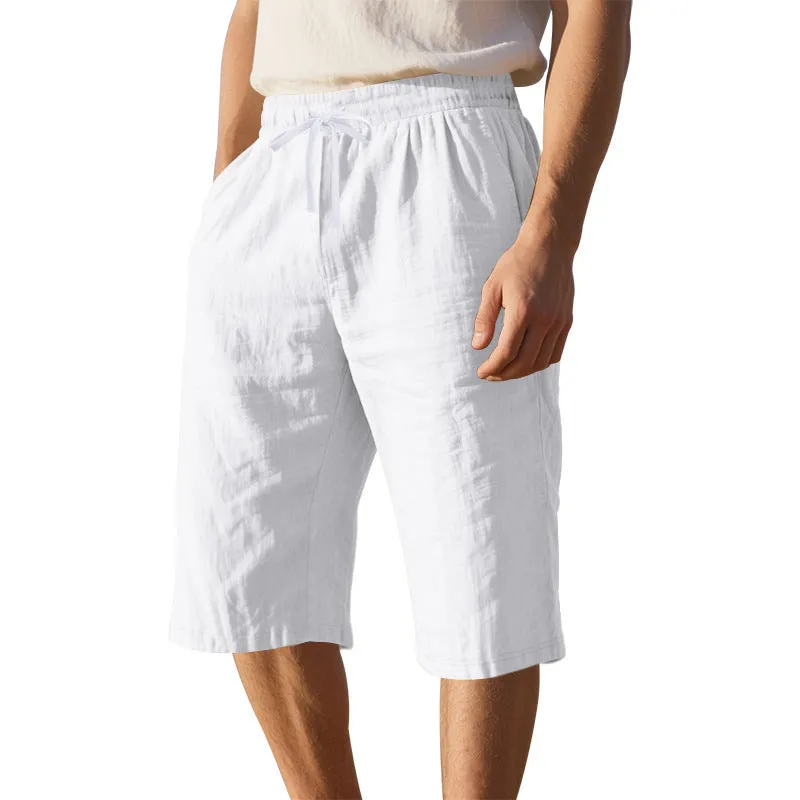 Men's light khaki linen shorts with a drawstring waistband and loose, cropped leg fit.