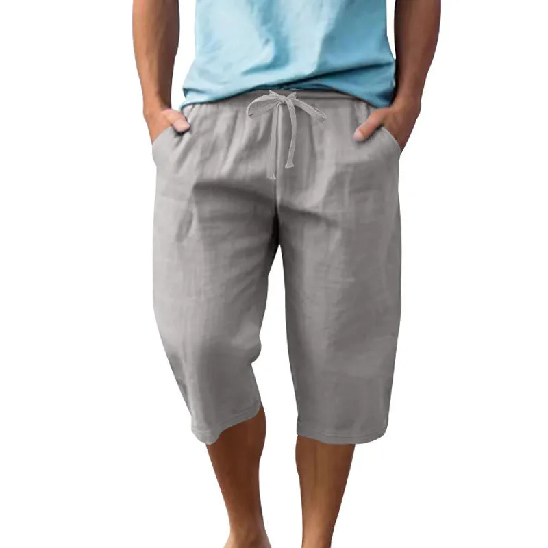 Men's light khaki linen shorts with a drawstring waistband and loose, cropped leg fit.