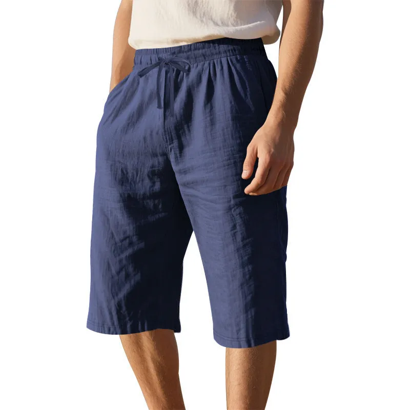 Men's light khaki linen shorts with a drawstring waistband and loose, cropped leg fit.