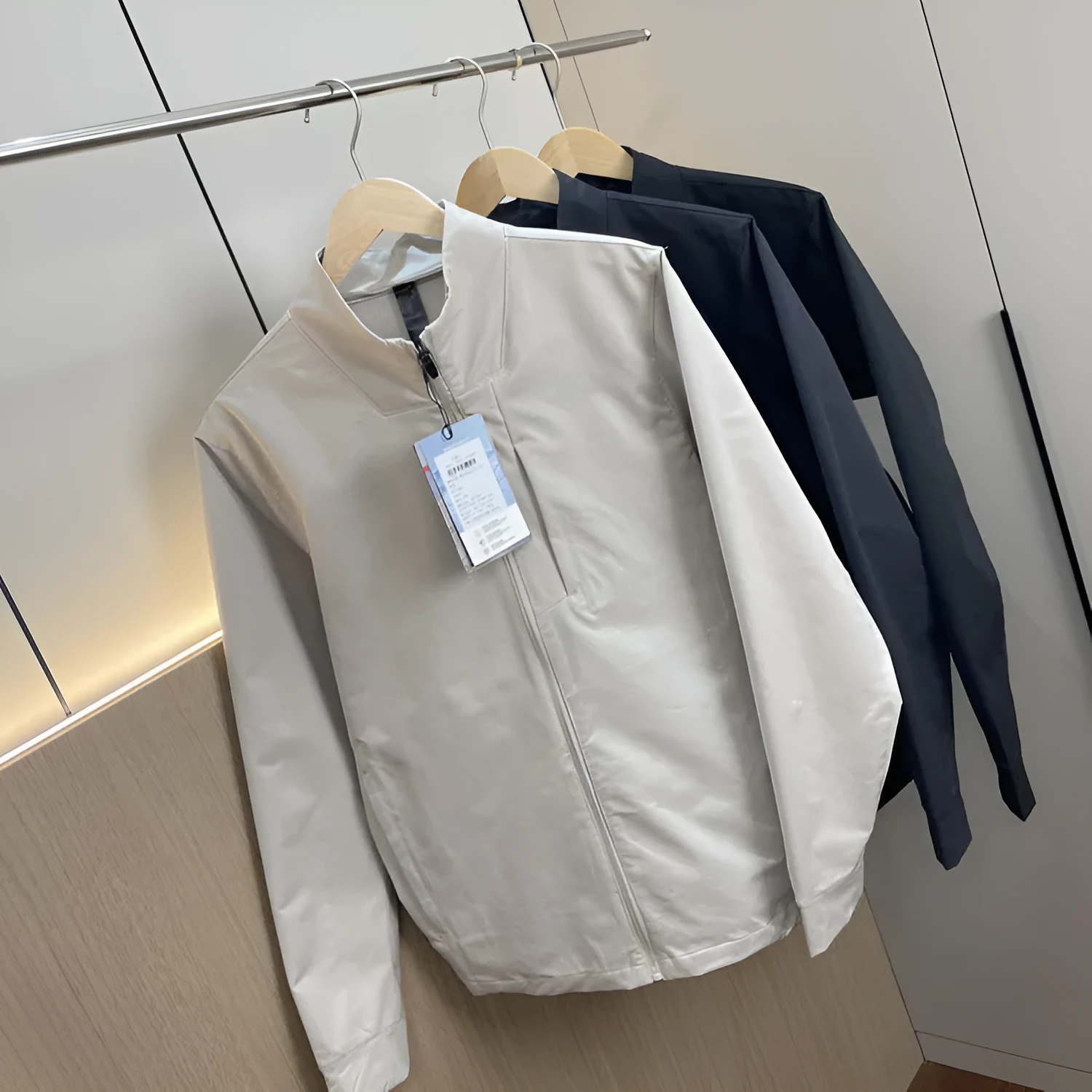 Man wearing a beige stand collar polyester casual jacket with long sleeves and a straight hem.