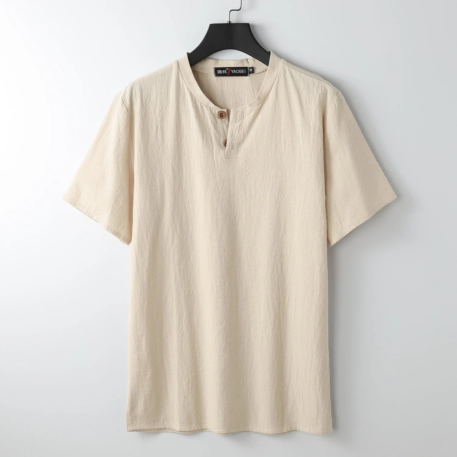Women's loose-fit apricot coloured V-neck short sleeve cotton top on a hanger.