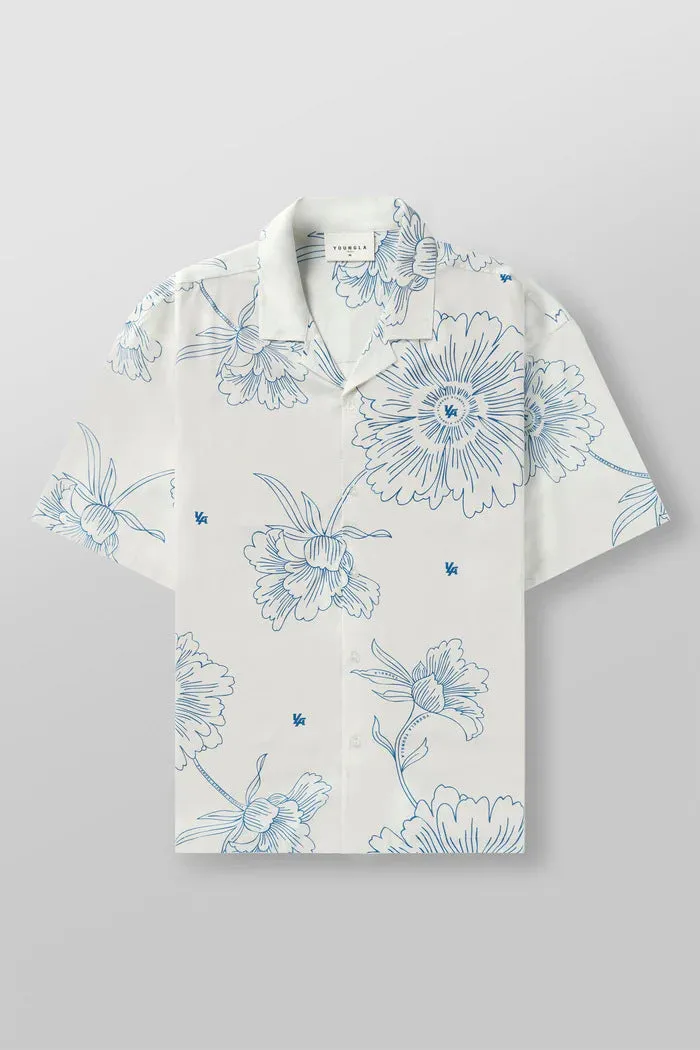 Man wearing a loose, short-sleeved printed floral top in a light colour.