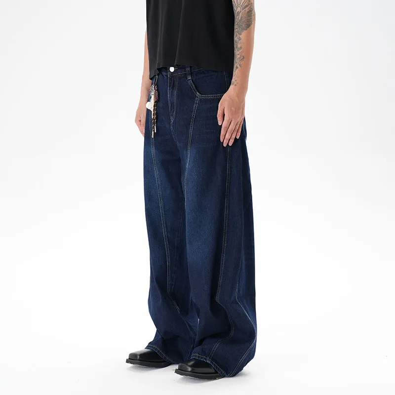 Dark blue washed distressed wide leg machete jeans on a model, showing the denim fabric and relaxed fit.